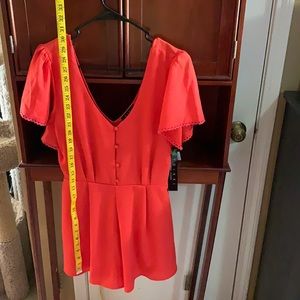 A jumpsuit size medium the color is orange:) never worn I am 5’6